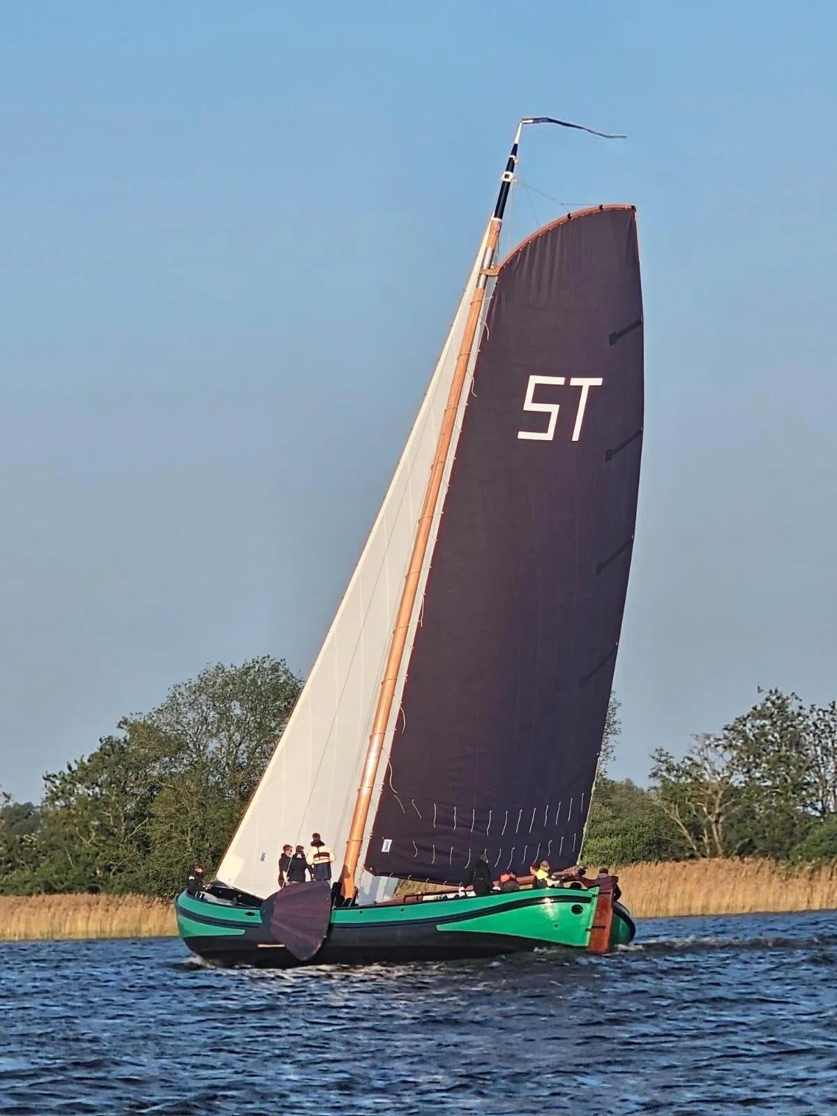 De Vrouwe Jantje alleen op het water, het ST-merk vol in beeld